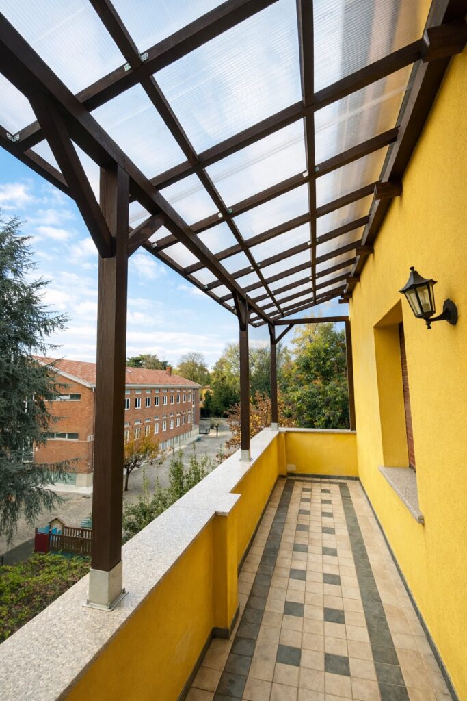 Pergola in legno su misura con copertura in policarbonato realizzata su terrazzo a Milano, larghezza 7,5 metri