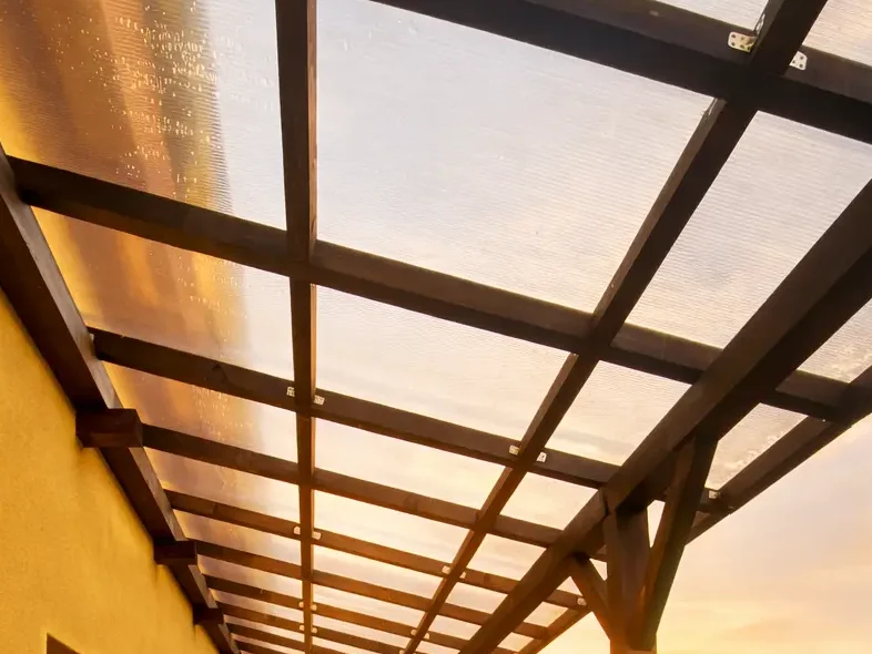 Pergola in legno su terrazzo a Milano con copertura in policarbonato trasparente